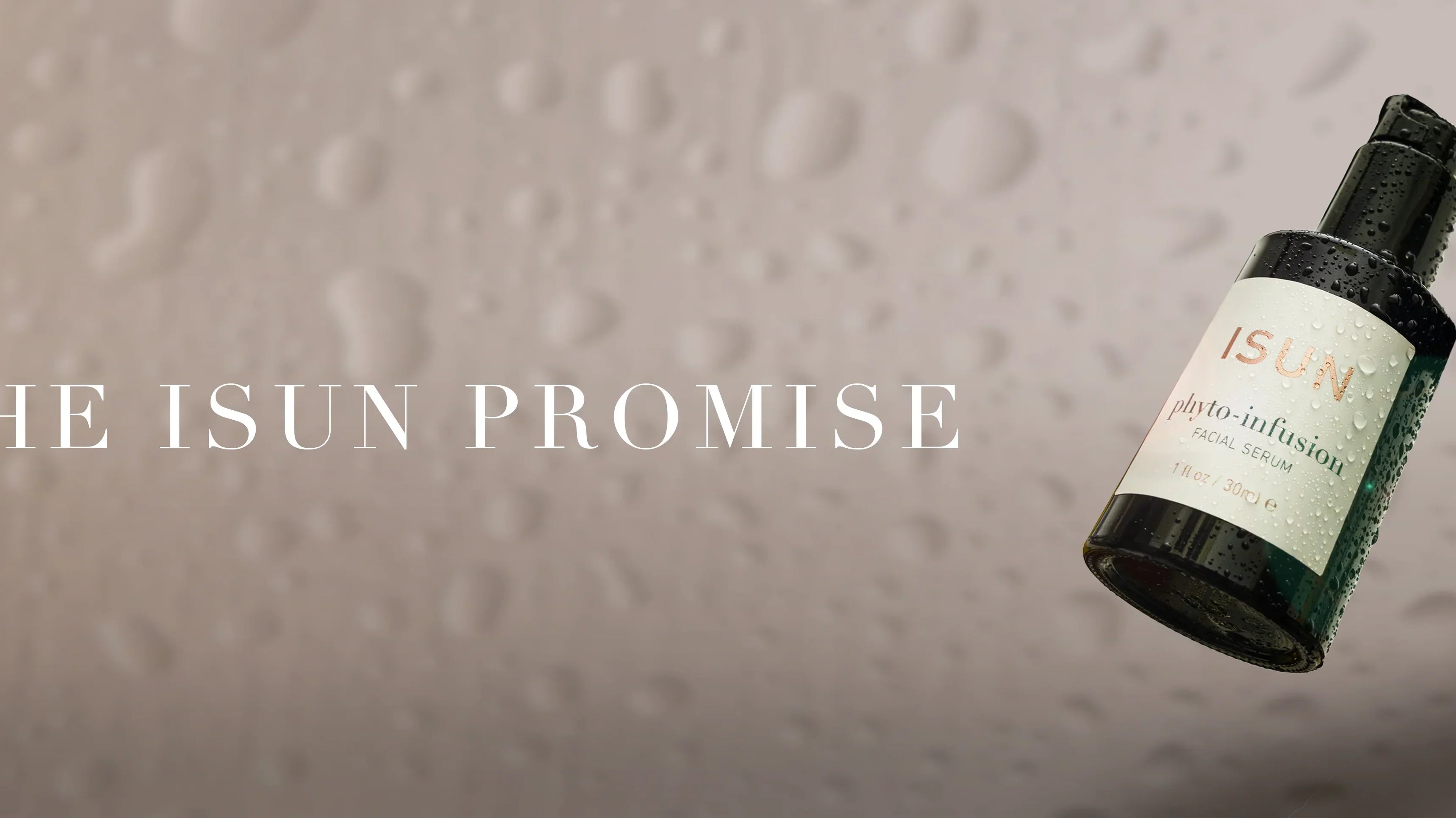 Glasflaske med Phyto-Infusion Serum på lys bakgrunn, omgitt av vanndråper og teksten - The ISUN Promise.