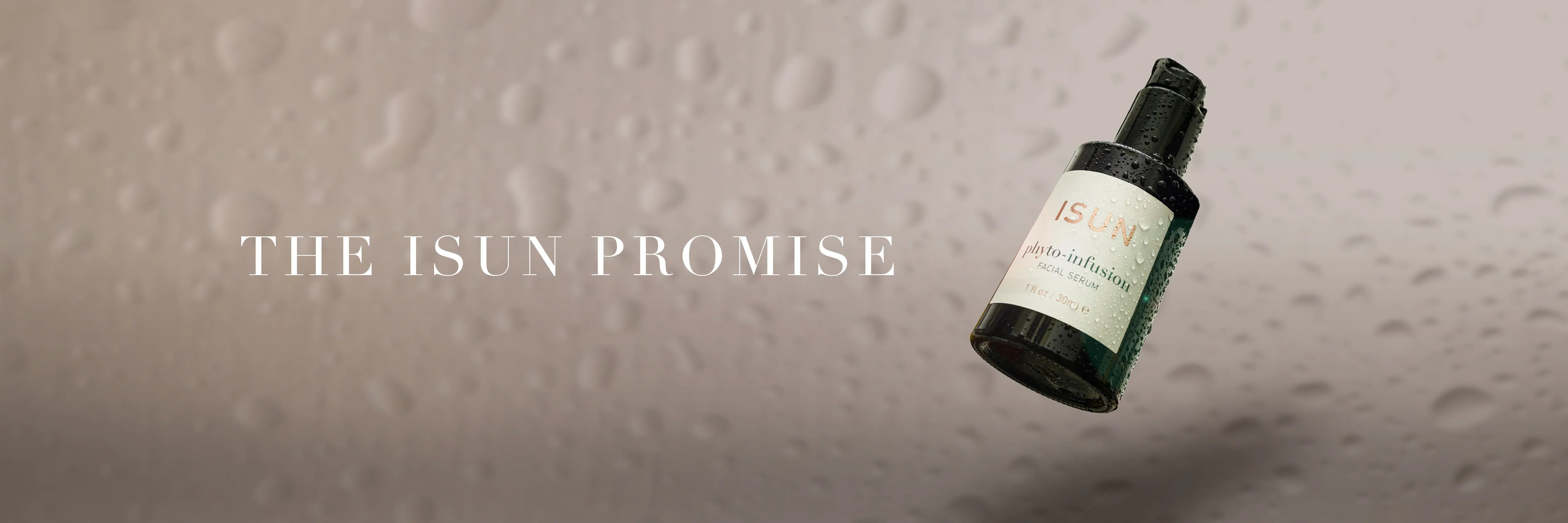 Glasflaske med Phyto-Infusion Serum på lys bakgrunn, omgitt av vanndråper og teksten - The ISUN Promise.
