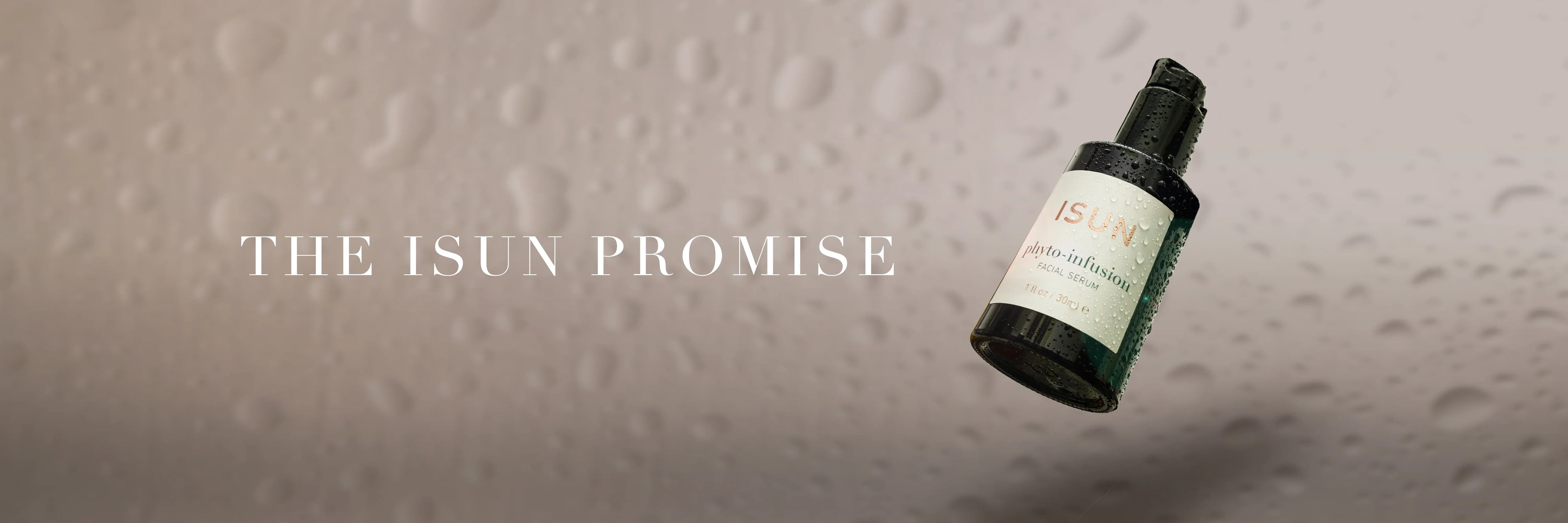 Glasflaske med Phyto-Infusion Serum på lys bakgrunn, omgitt av vanndråper og teksten - The ISUN Promise.
