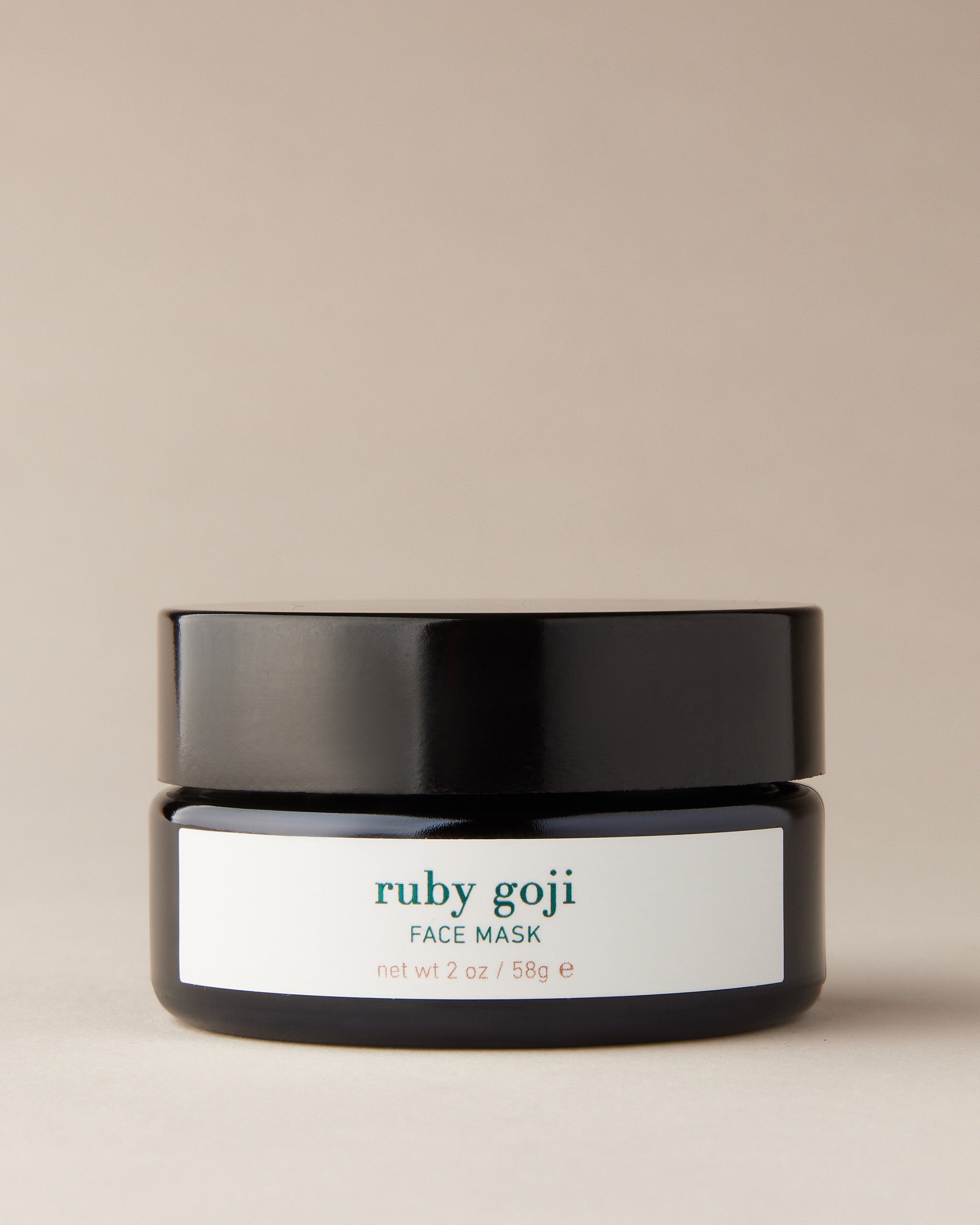 En elegant, svart krukke med en ren, hvit etikett mot en lys bakgrunn.