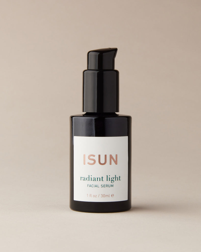 Bottle of ISUN Radiant Light Serum on a beige background