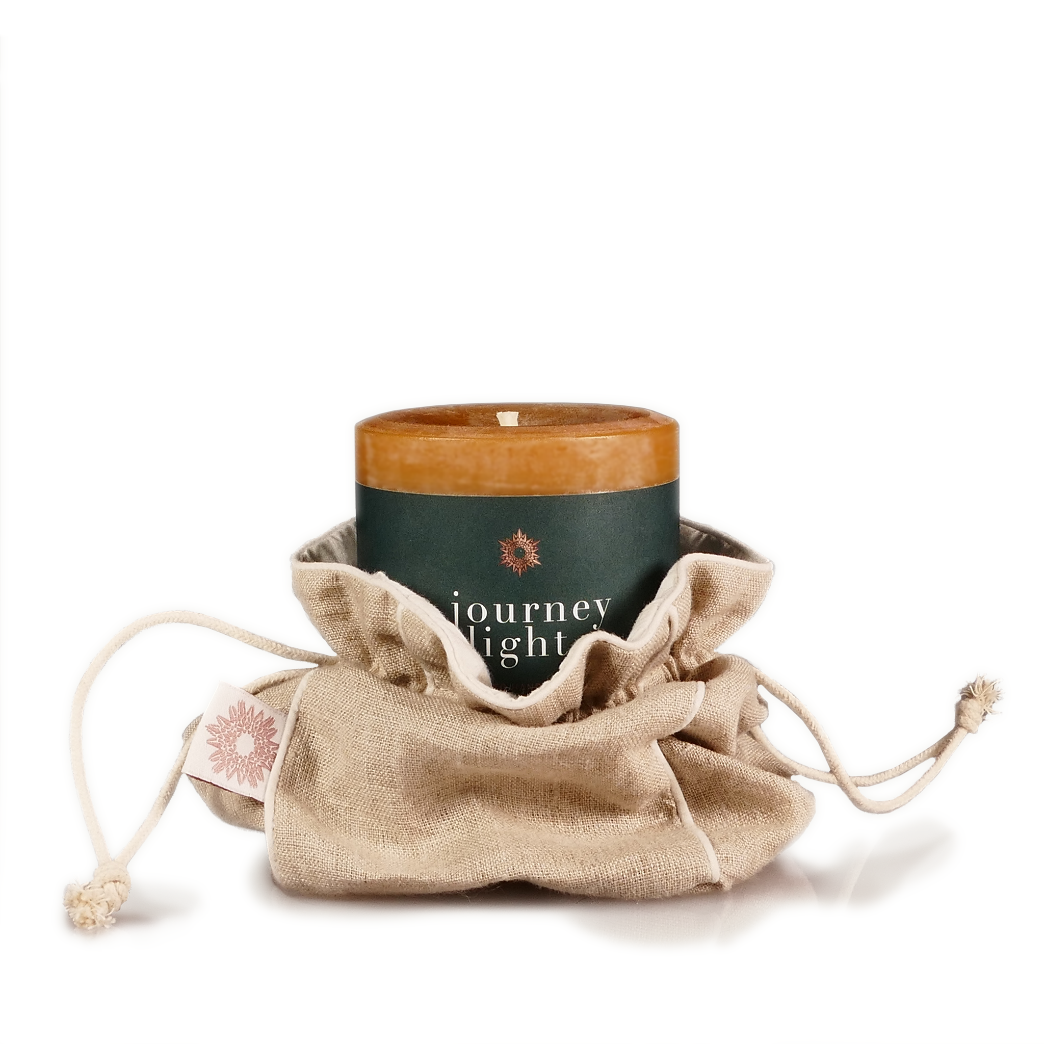 Stearinlys plassert i en beige linpose mot hvit bakgrunn.