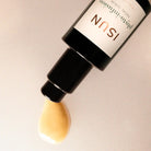 Flaske som ligger på siden med Phyto-Infusion ansiktsserum som renner ut