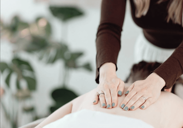 Hender som utfører ryggmassasje
