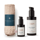 ISUN Restore Ritual med Ruby Cleanse, Ultra Ruby Facial Oil og en sammenrullet ansiktsklut i bomull på hvit bakgrunn.